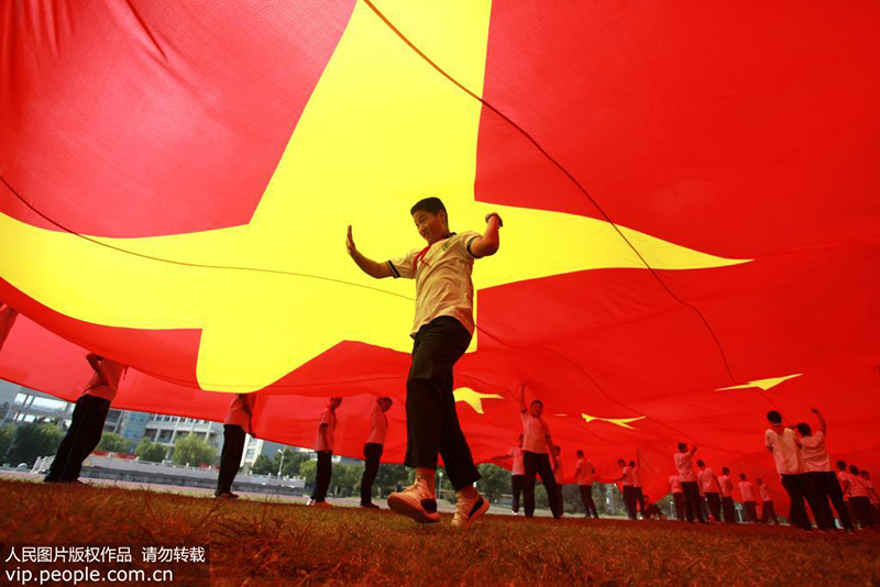 9月28日，江苏扬州千名学生齐摆“70”巨幅五星红旗喜迎国庆。